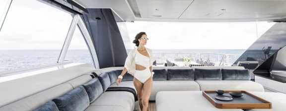 Woman in White Bathing Suit Walking Along an indoor Yacht Deck