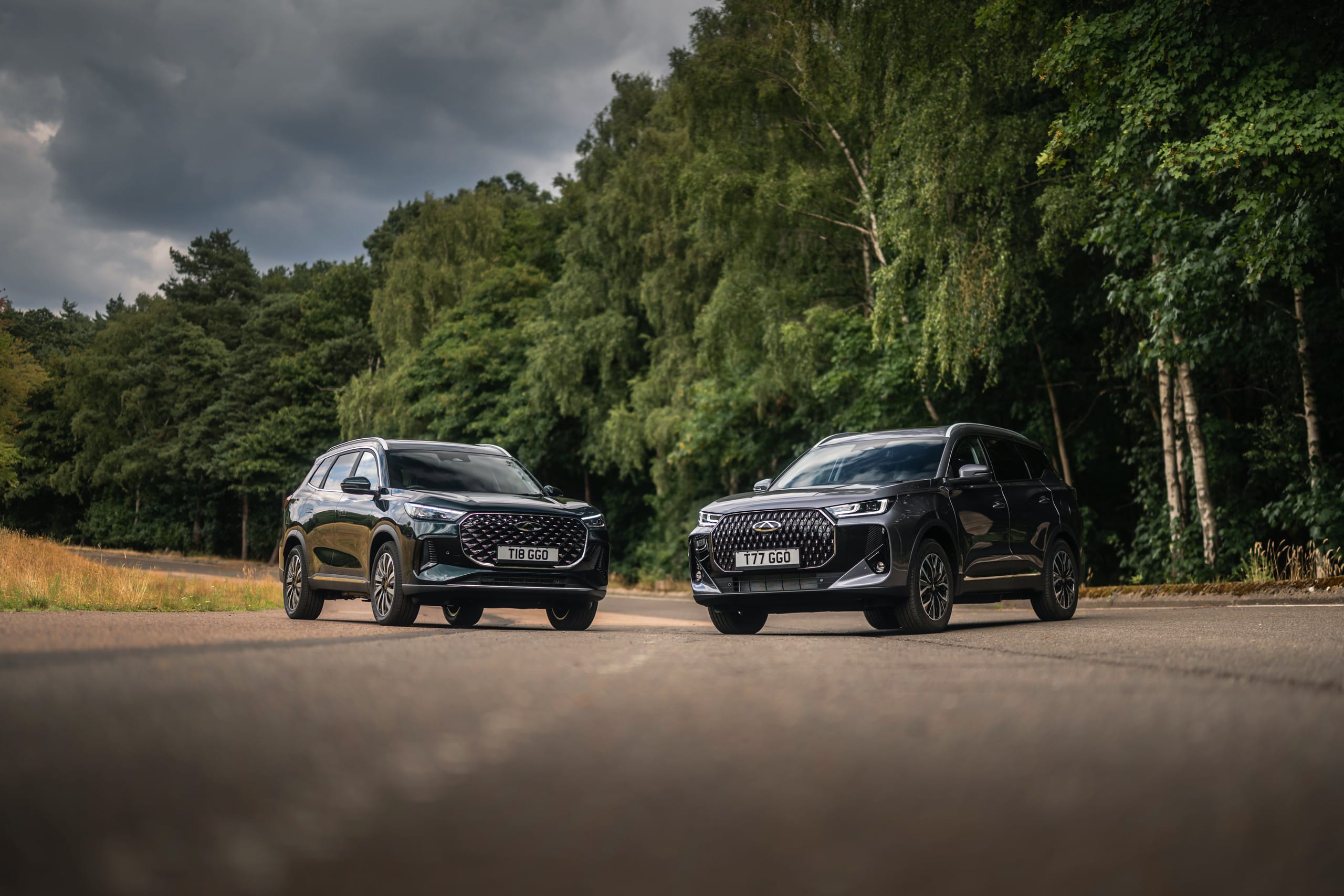 Two Chery TIGGO models on a woodland road