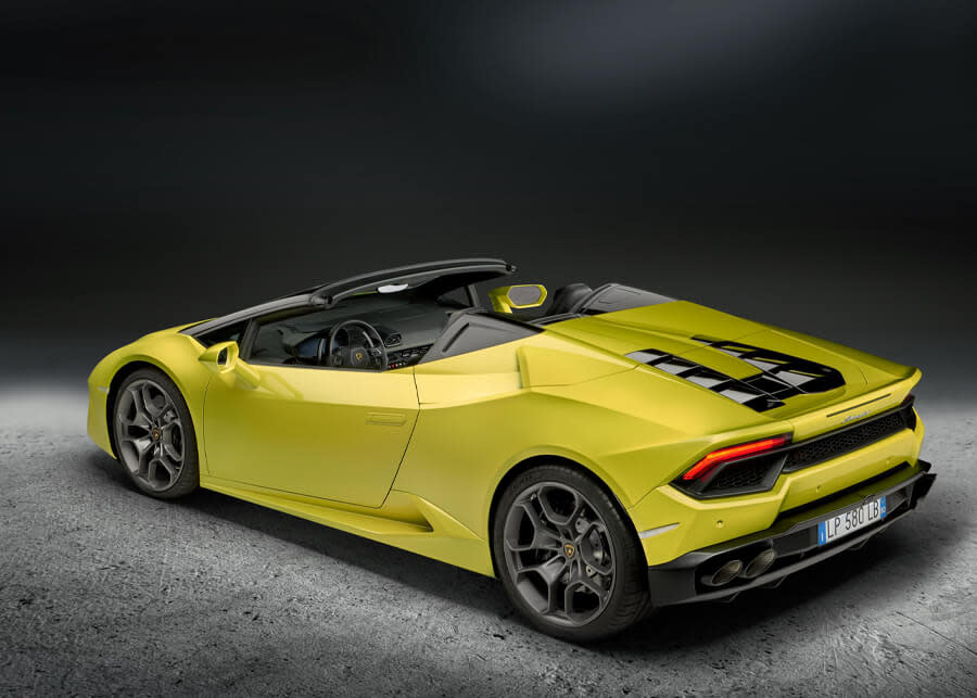 ルーフを開いたランボルギーニ・ウラカンRWDスパイダーのサイドプロフィール。シャープなラインとスポーティなリアが際立つ、都会の環境に駐車。