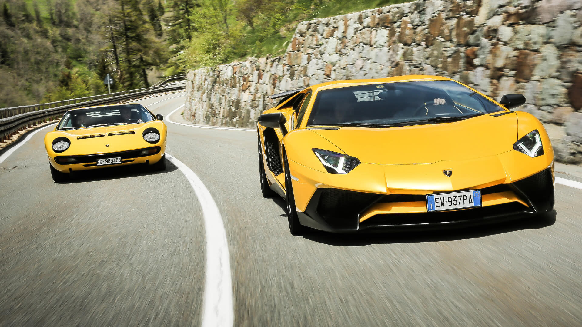 Una serie di veicoli Lamborghini esposti in un paesaggio montano