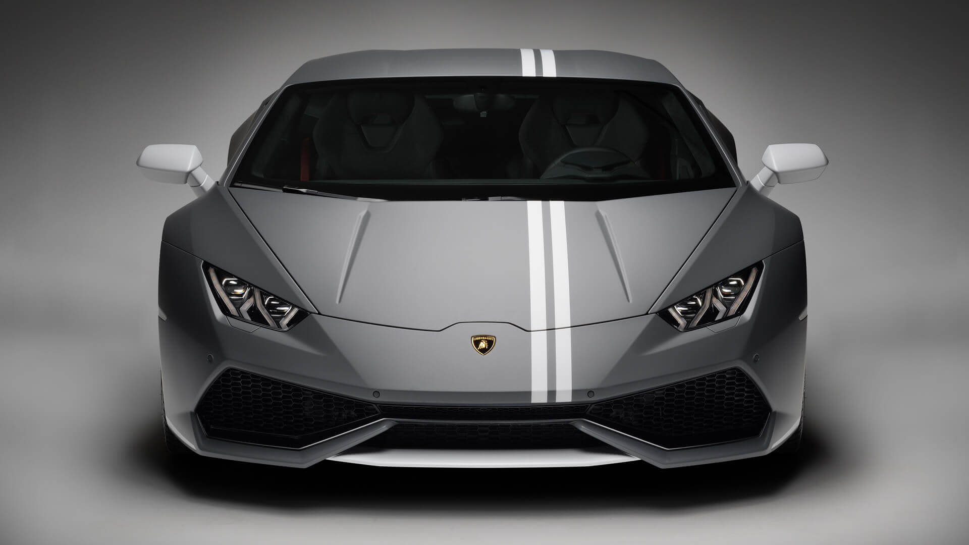 Lamborghini Huracán Avio in marcia lungo una strada di campagna aperta al tramonto, con strisce distintive e design aerodinamico