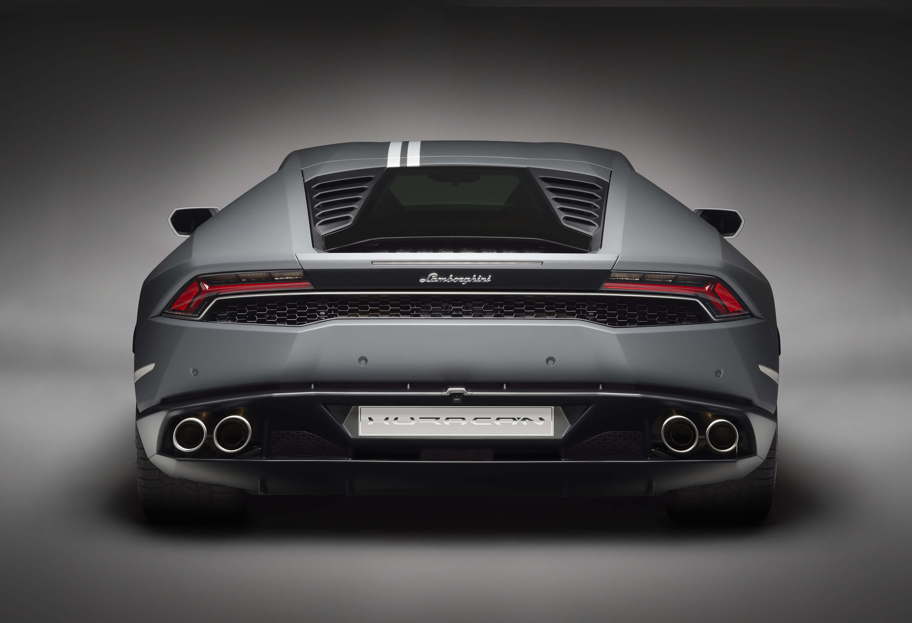 Lamborghini Huracán Avio in marcia lungo una strada di campagna aperta al tramonto, con strisce distintive e design aerodinamico