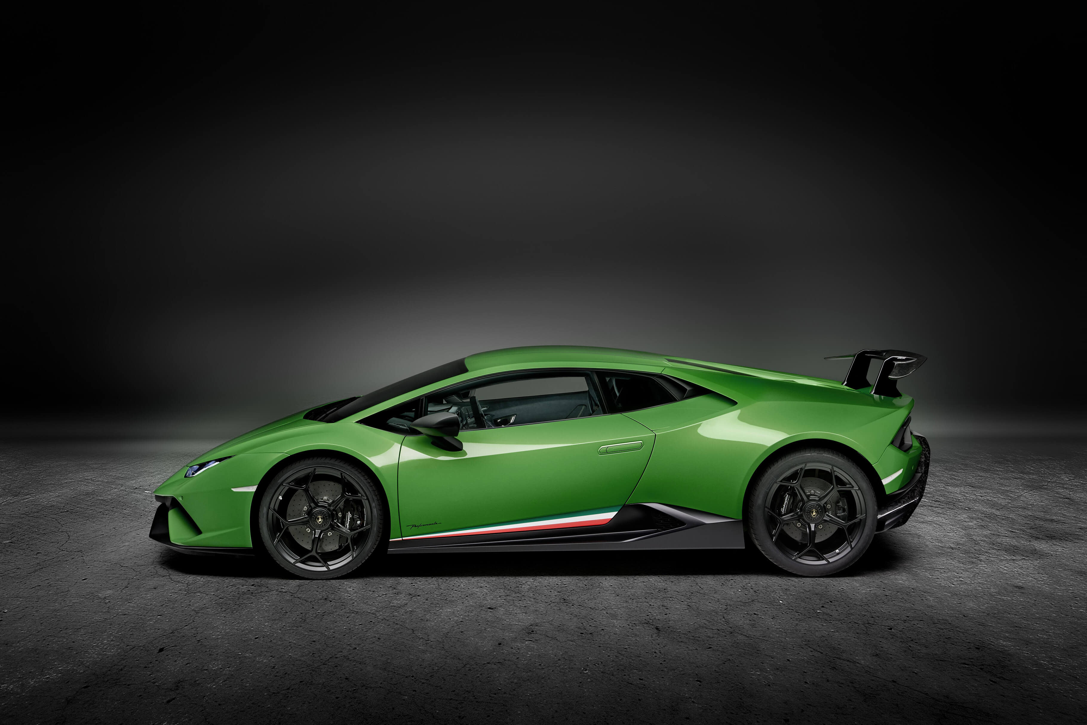 Lamborghini Huracán Performante on track, rear angle view during high-speed cornering, showcasing active aerodynamics and rear wing