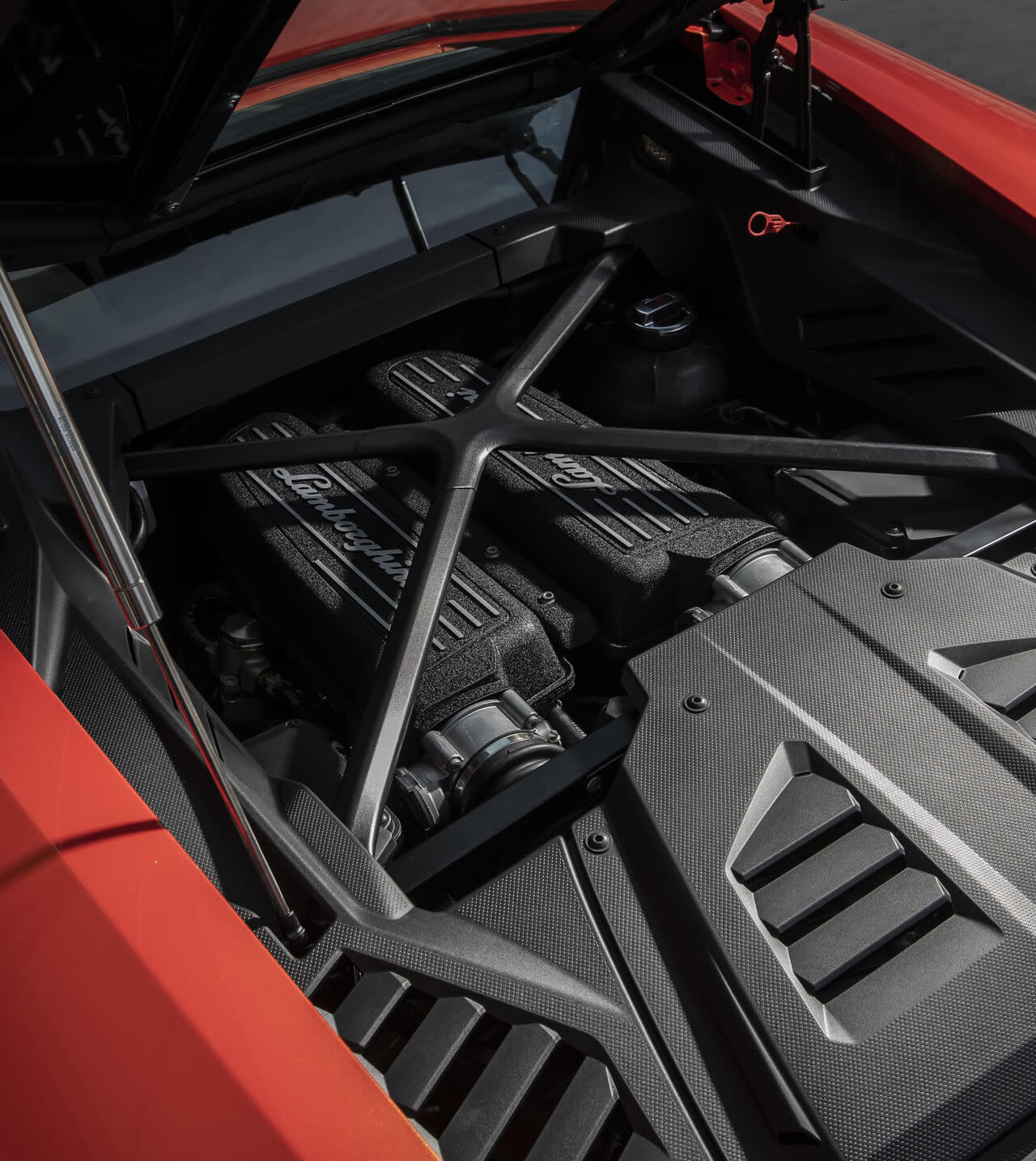 Vista trasera de un Lamborghini Huracán EVO en la sala de exposición de un concesionario, capturada con una suave iluminación interior.
