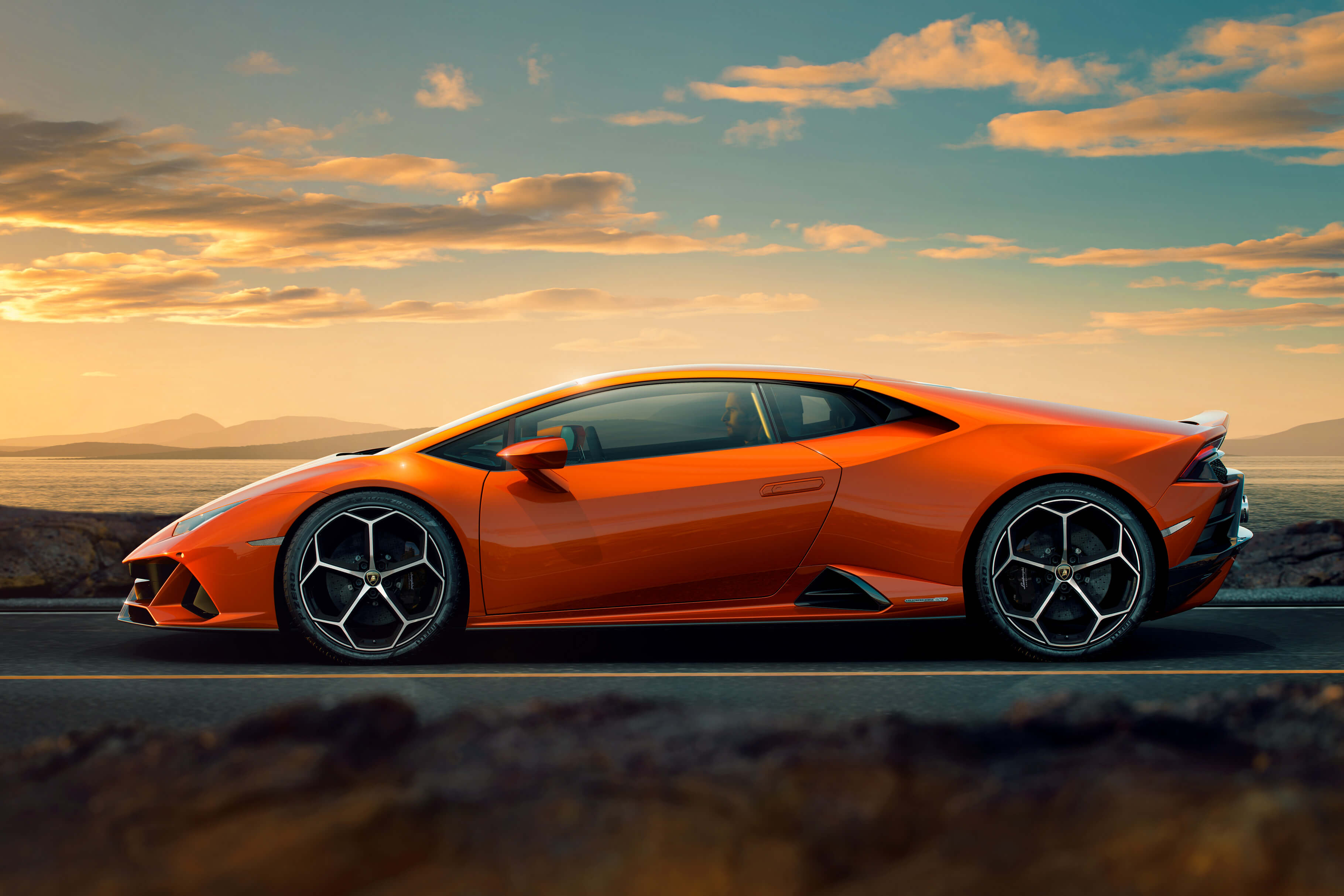 Lamborghini Huracán EVO conduciendo a gran velocidad en una pista, tomando curvas agresivamente bajo un cielo nublado