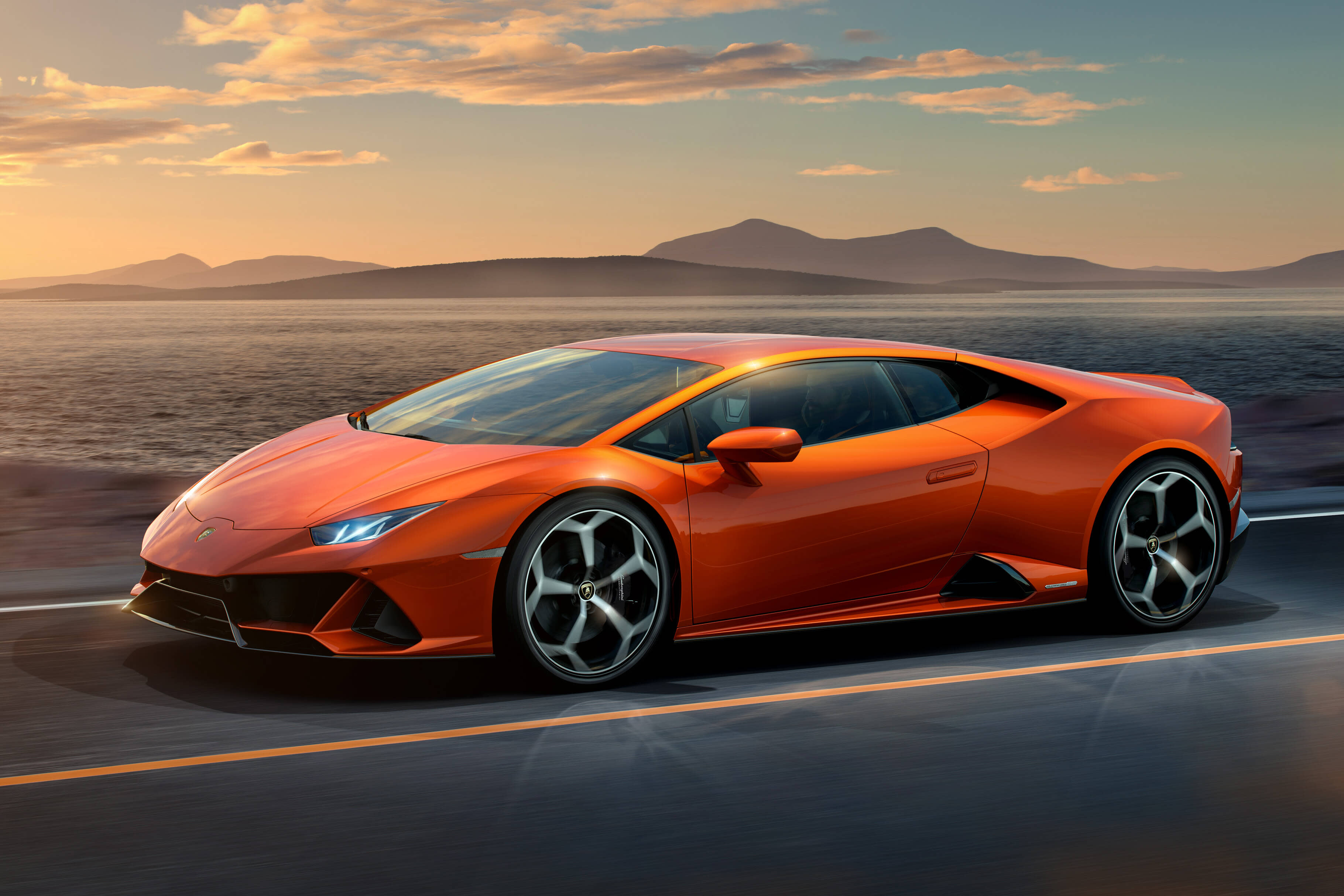 Lamborghini Huracán EVO conduciendo a gran velocidad en una pista, tomando curvas agresivamente bajo un cielo nublado