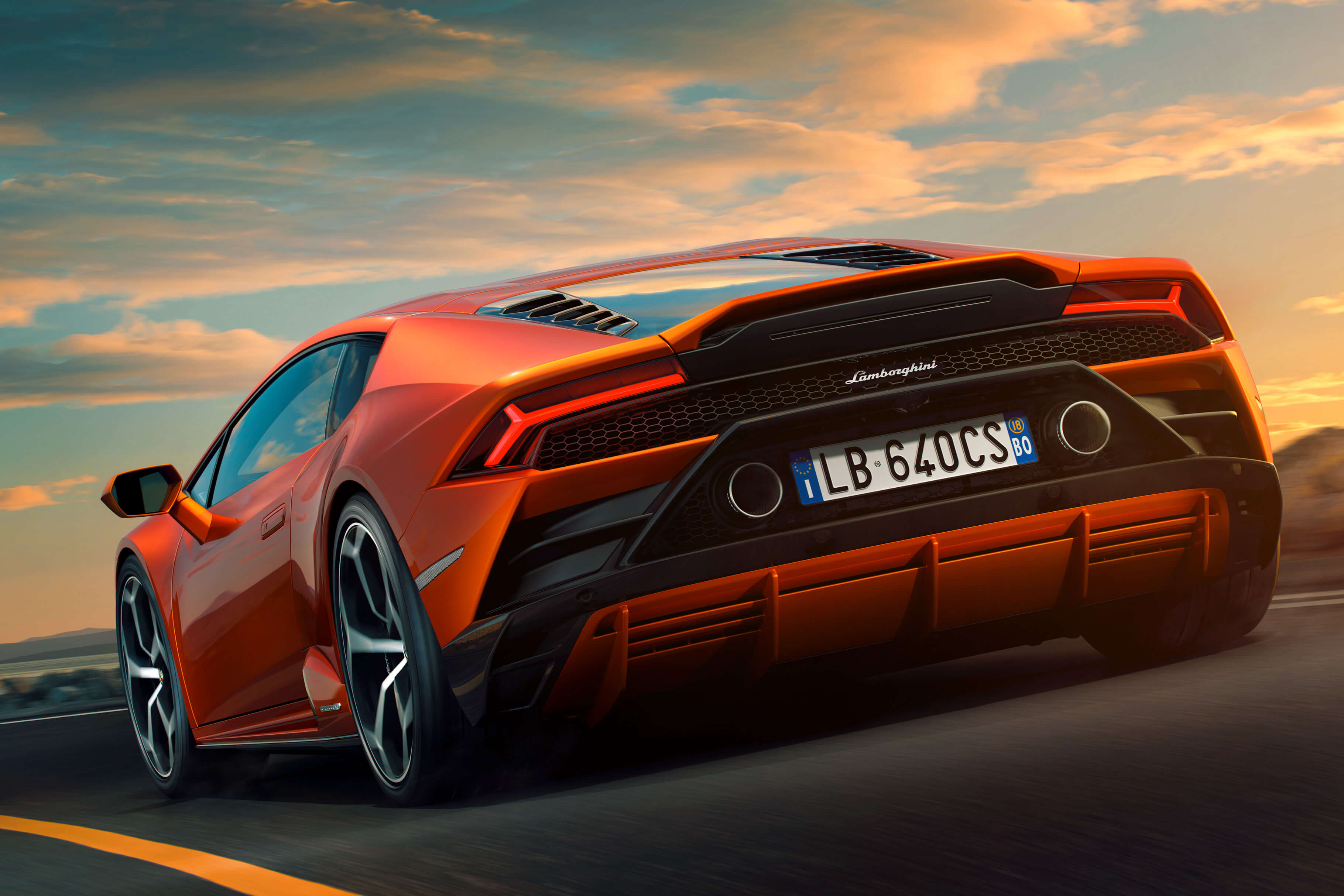 Lamborghini Huracán EVO conduciendo a gran velocidad en una pista, tomando curvas agresivamente bajo un cielo nublado