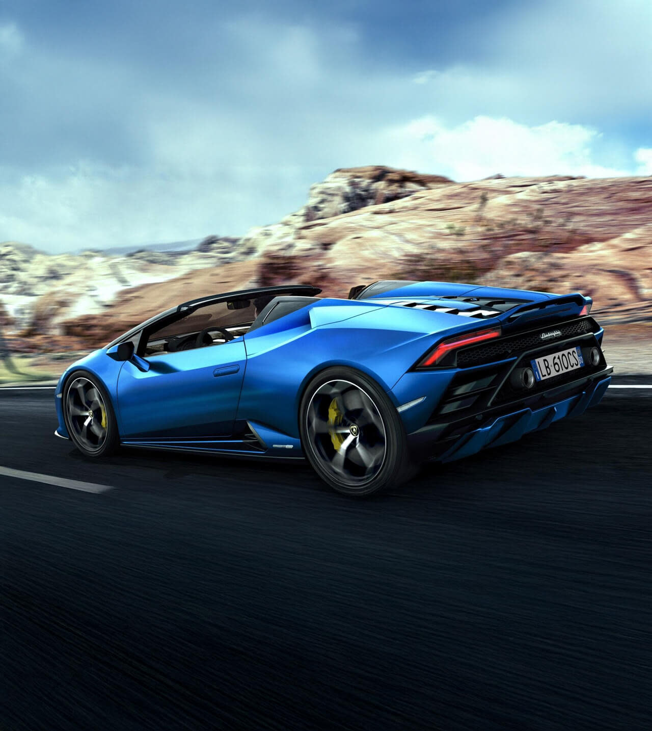 Rückansicht eines Lamborghini Huracán EVO RWD Spyder, der auf einer Kopfsteinpflasterstraße in der Nähe eines historischen Gebäudes geparkt ist