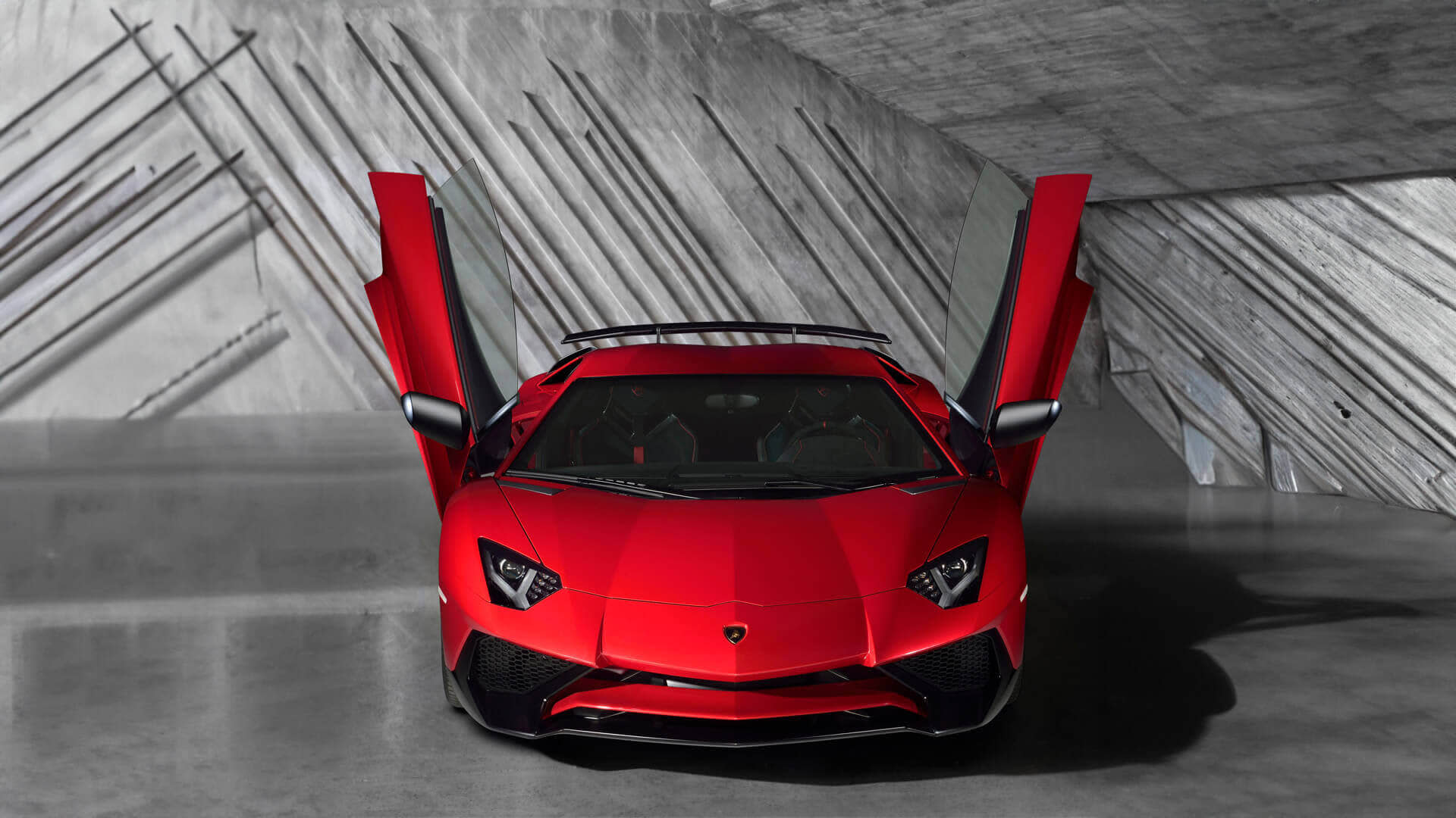Боковой профиль Lamborghini Aventador Superveloce, движущегося по гоночной трассе под облачным небом.