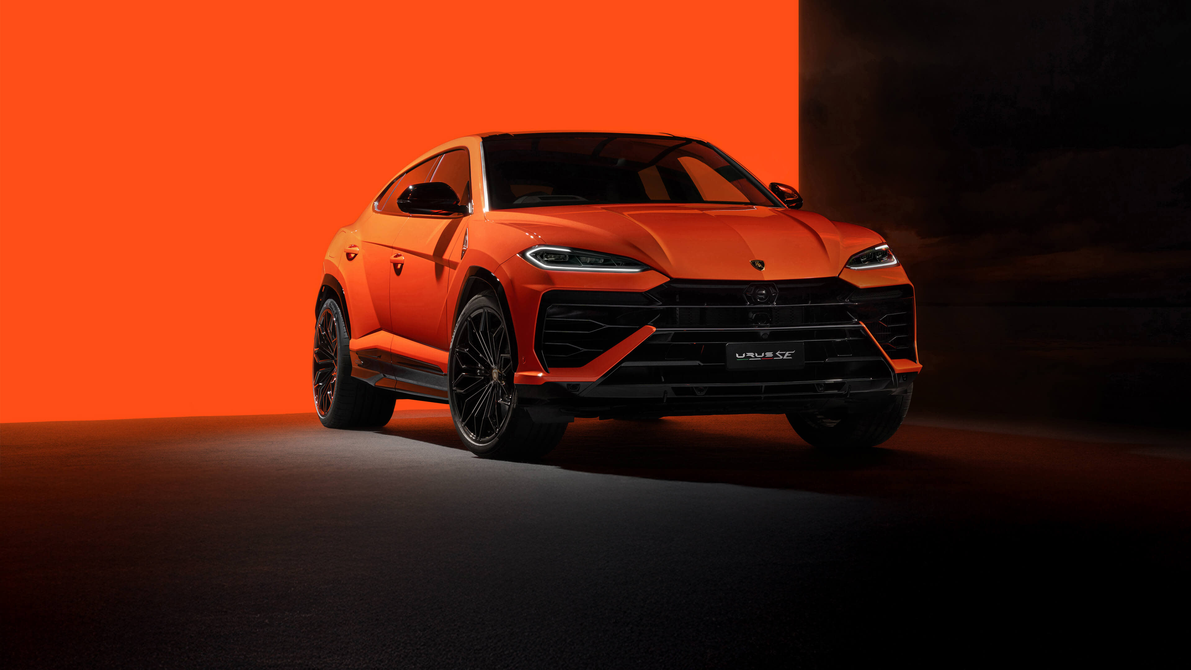 兰博基尼 Urus SE 正面图停放在现代建筑环绕的城市环境中