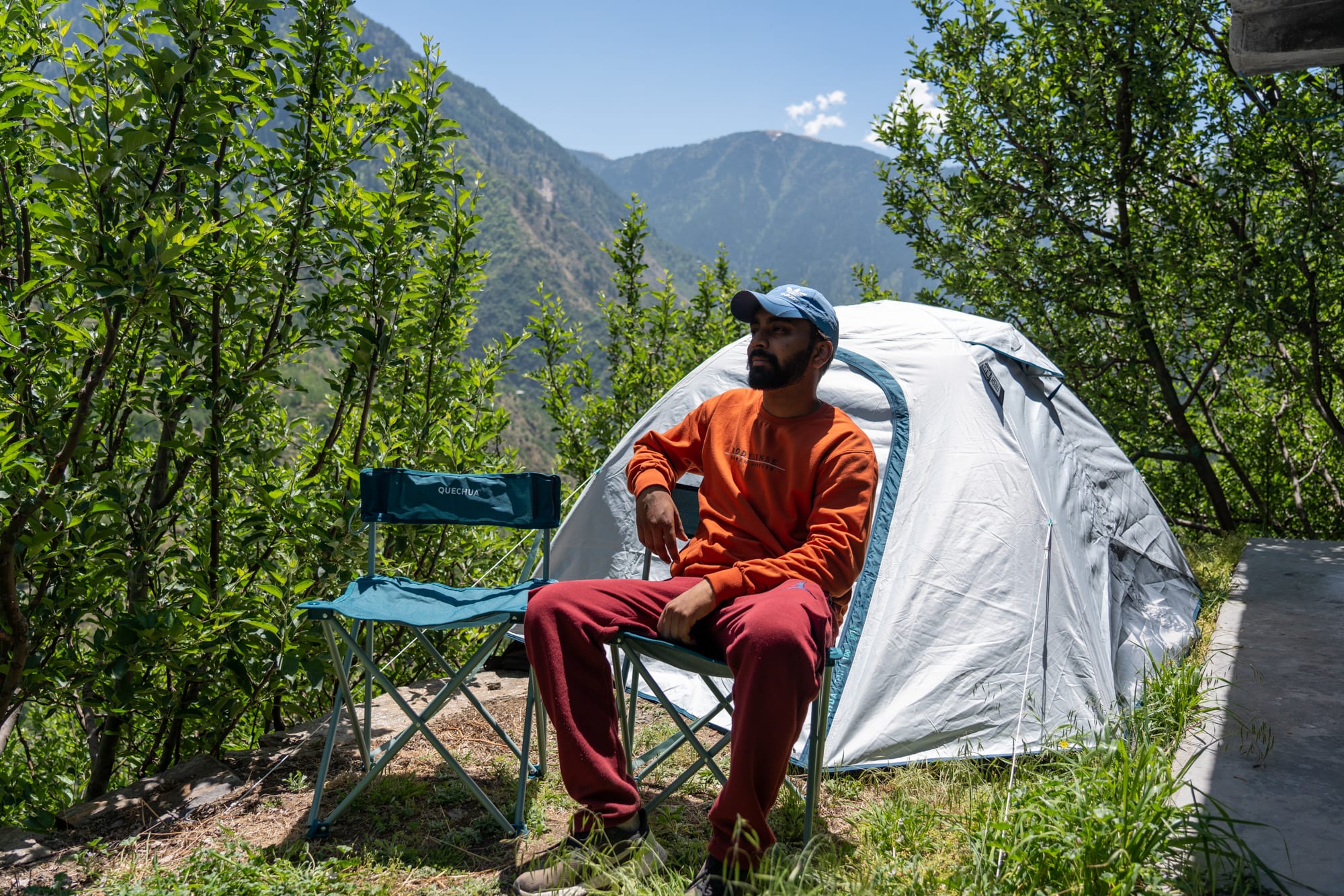 A man camping in an apple orchard