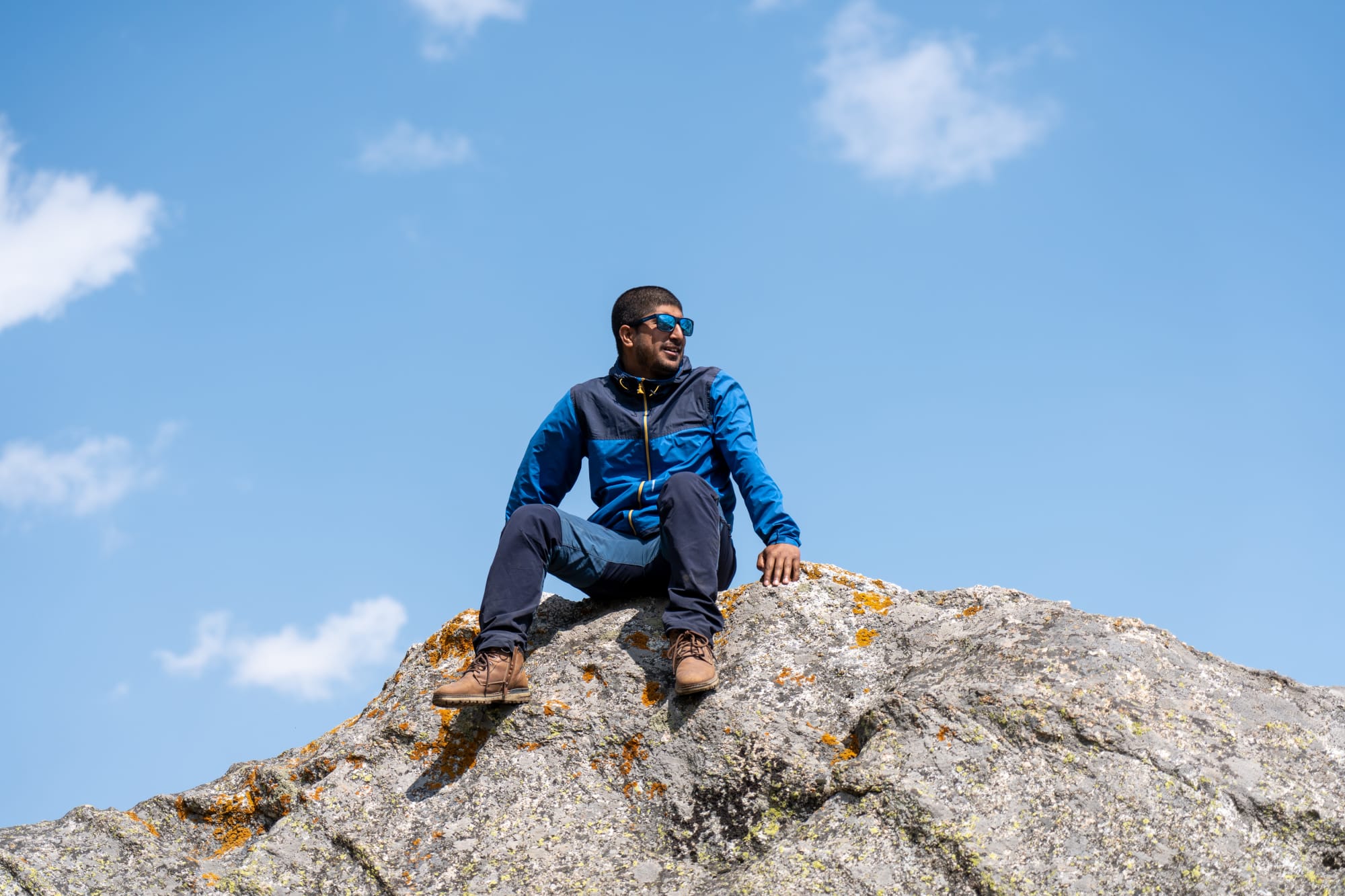 a person on a huge rock at Kara lake in Bhaba valley