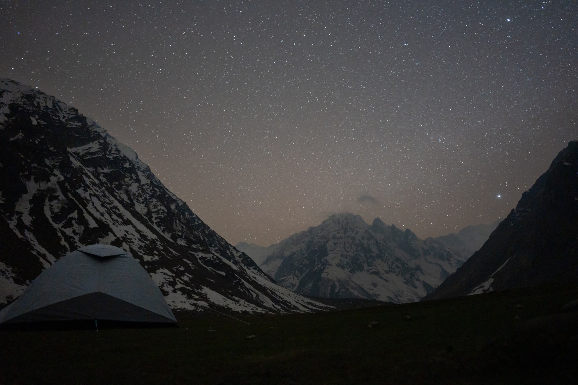 Stars and mountains with tent in foreground at kara lake