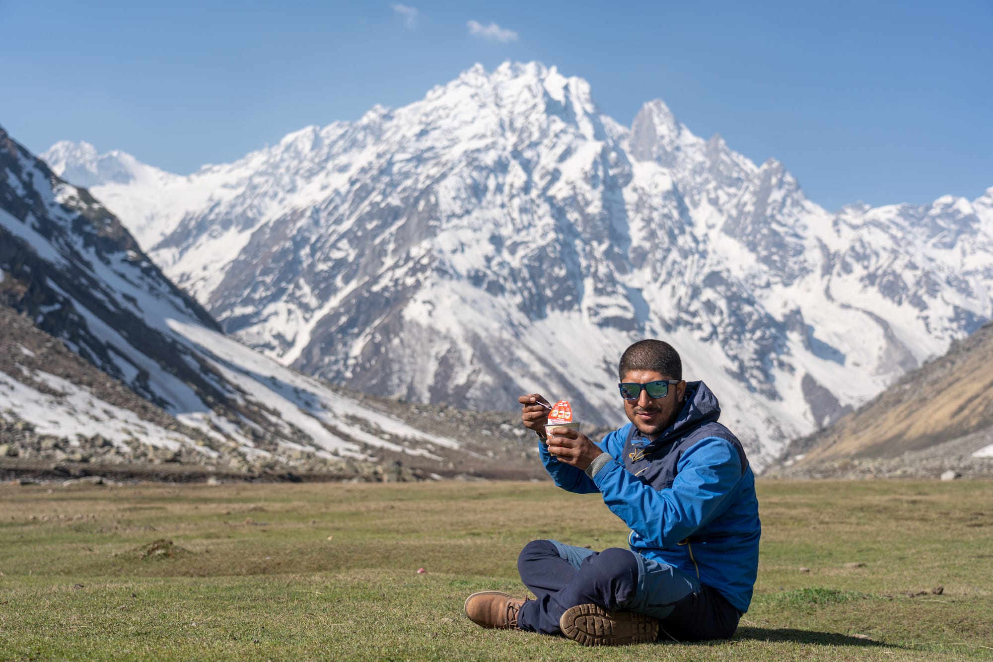 a man eating noodles at Kara lake with beautiful mountain in the background