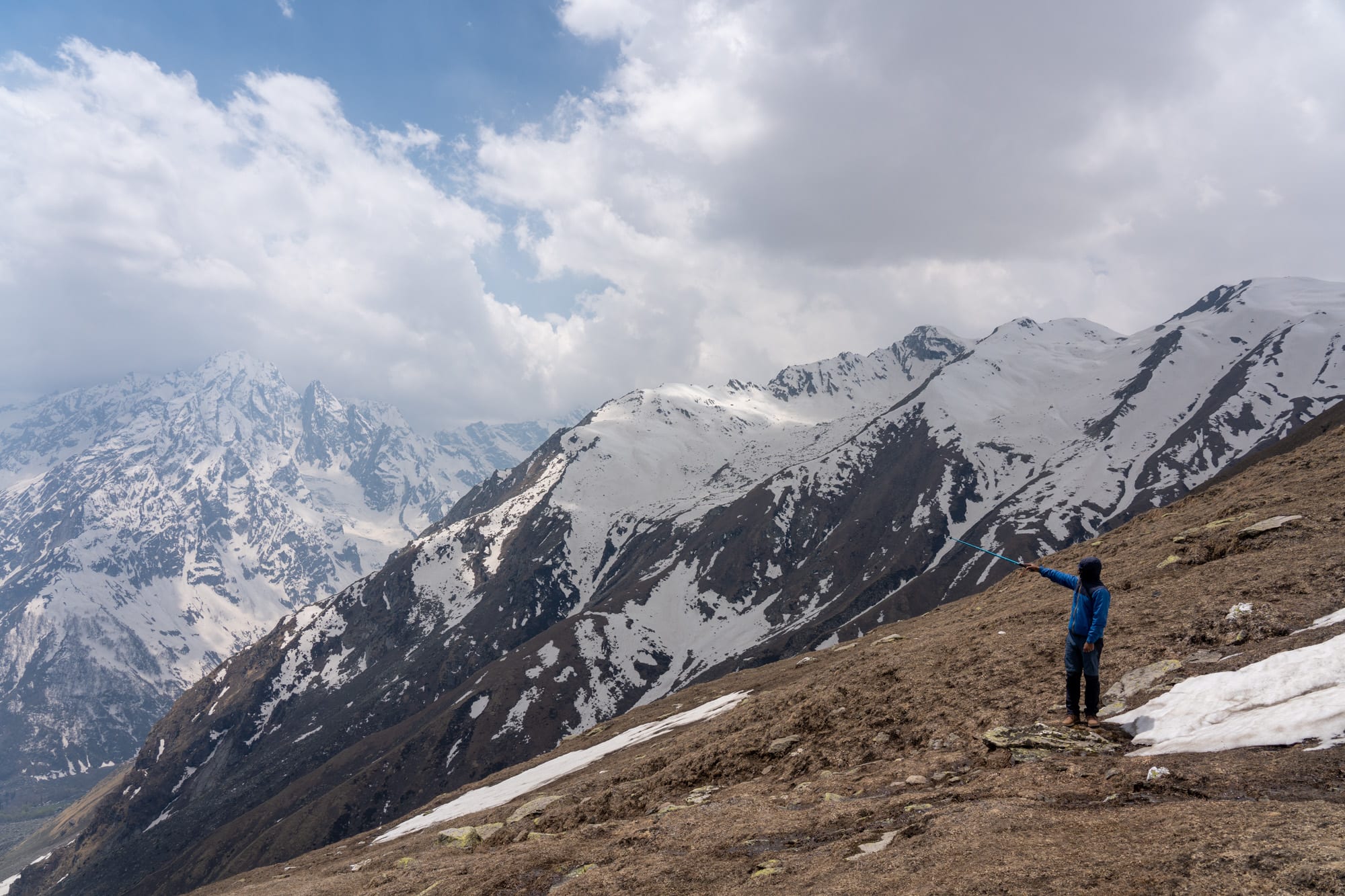 Person standing pointing with his stick at the Bhaba valley