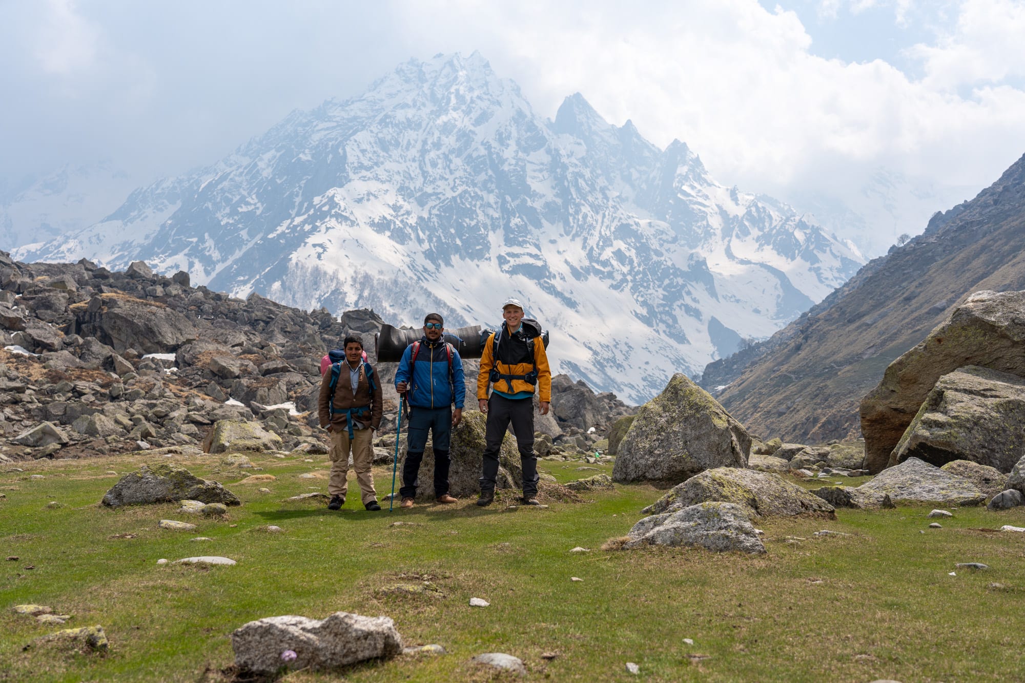 Group of people standing on green grass with beautiful mountain in the background