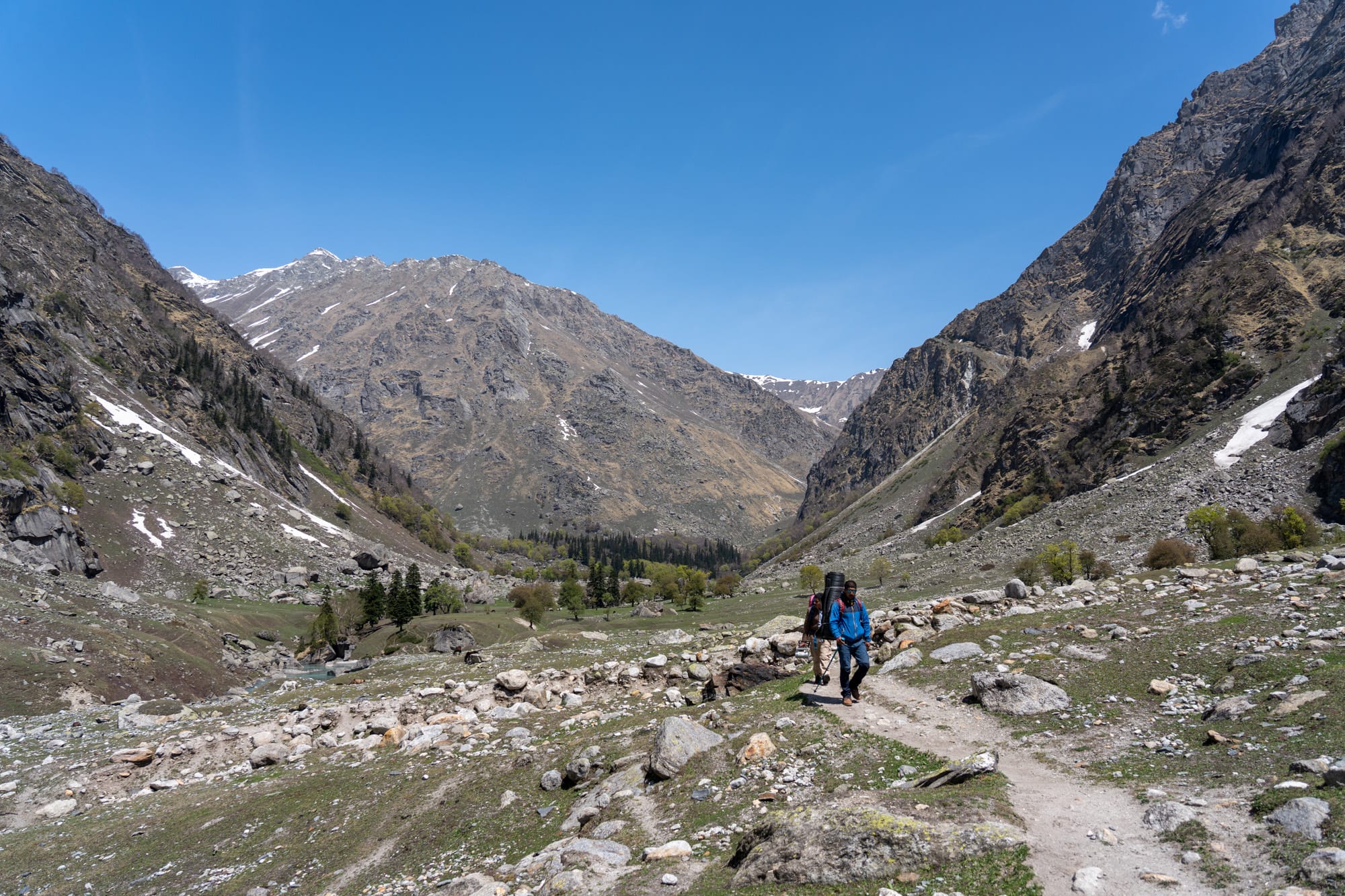 2 people walking on a rocky path in Bhaba valley