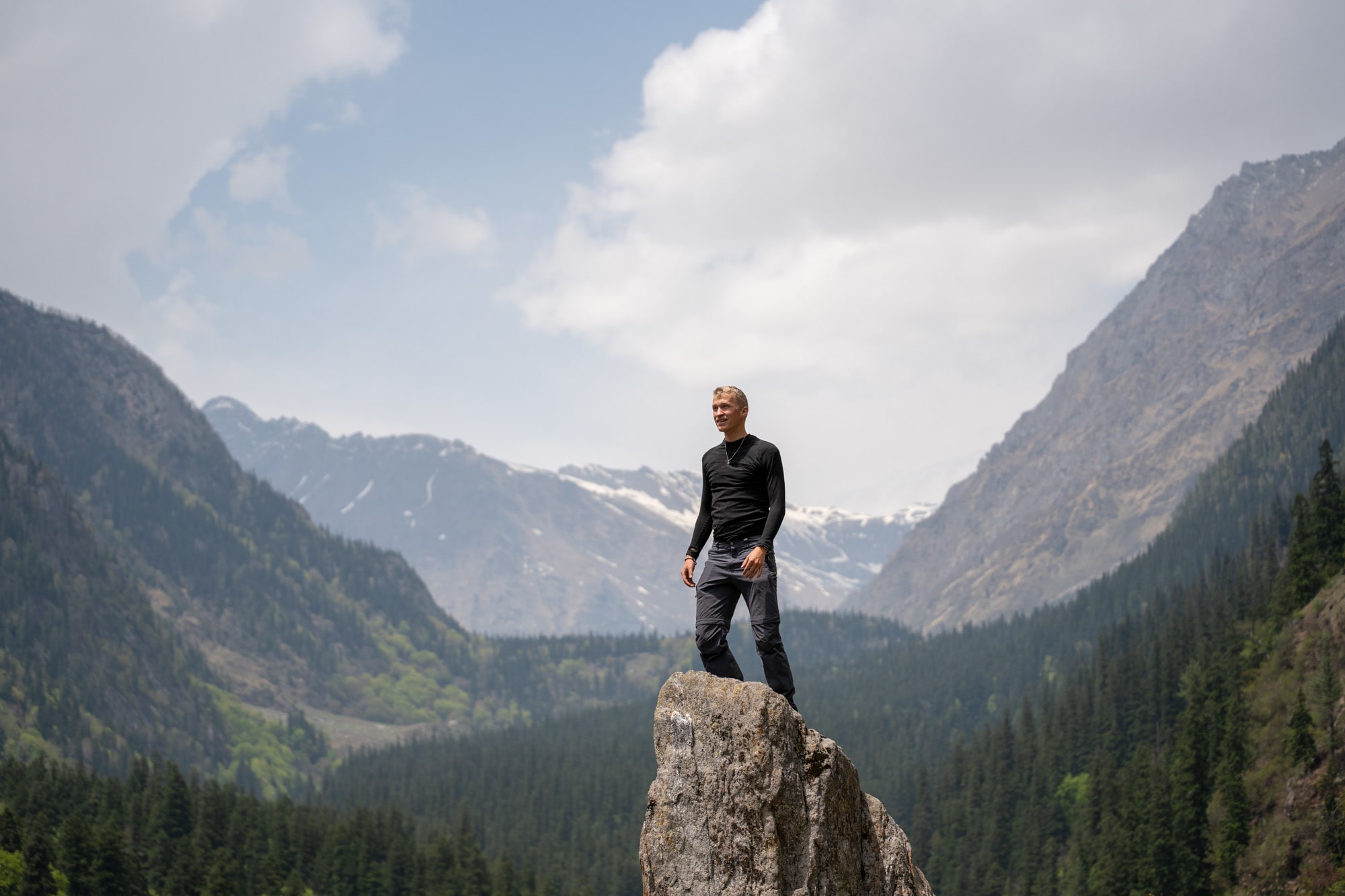 Man standing on a rock with the beatuiful green Bhaba valley in the background