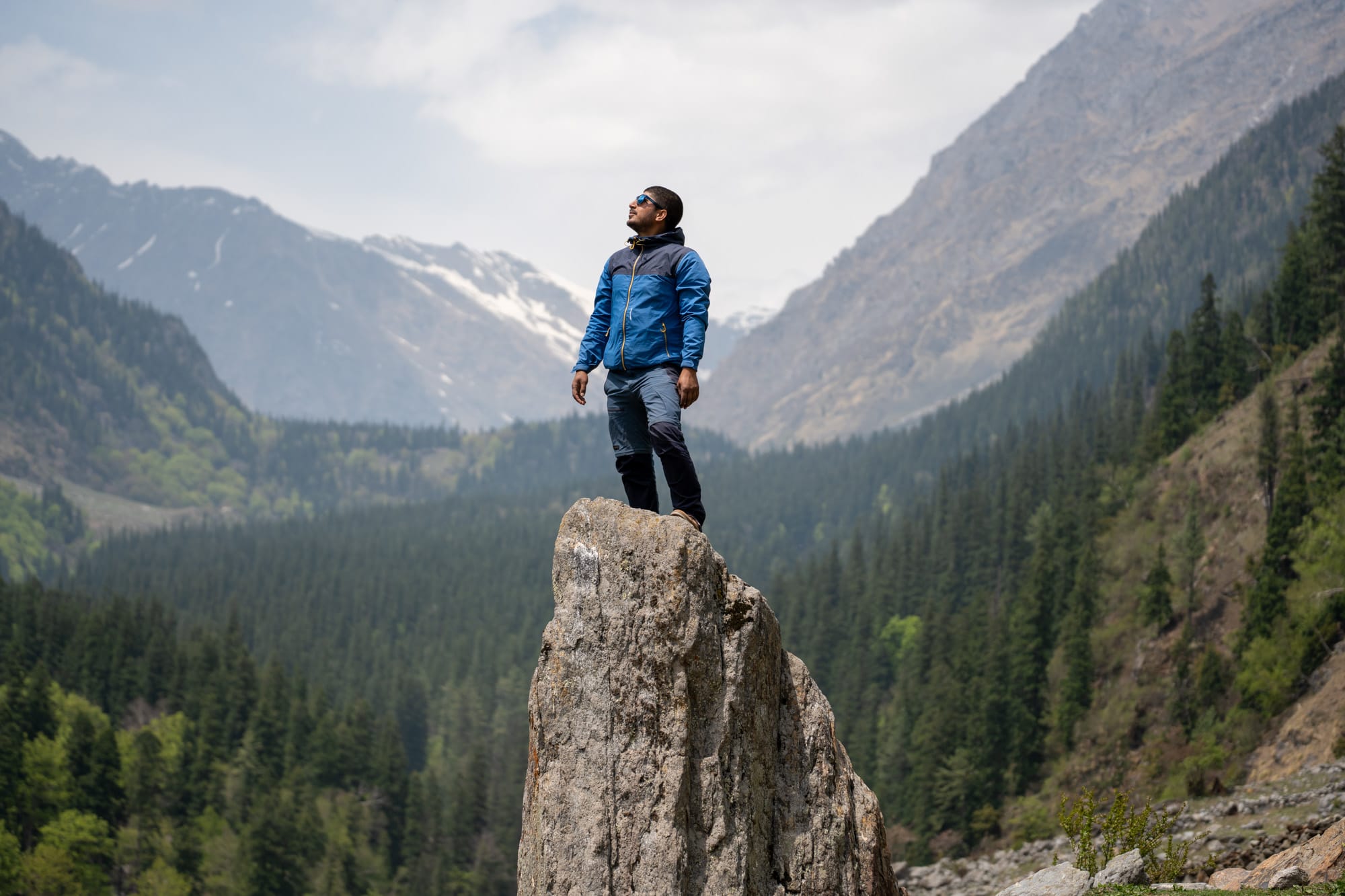 Man standing on a rock with the beatuiful green Bhaba valley in the background