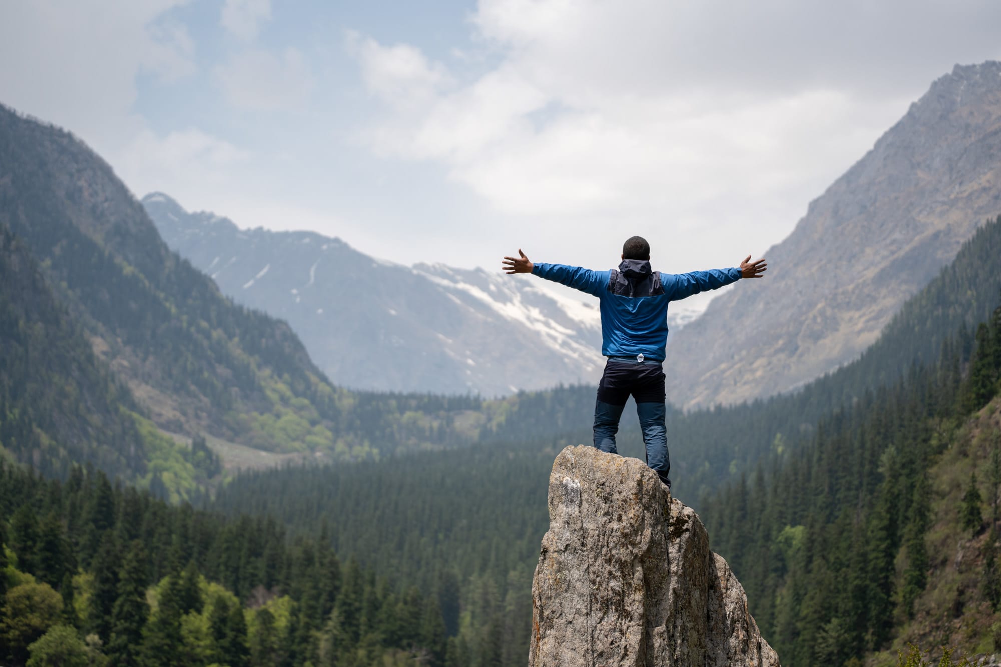 Man standing on a rock with the beatuiful green Bhaba valley in the background