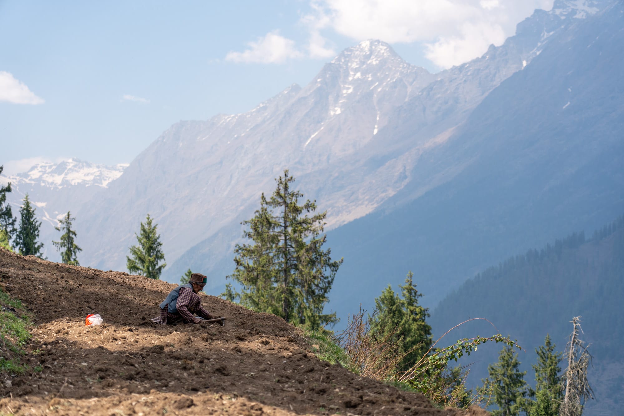 farmer on his field wiht beautiful mountains in the background