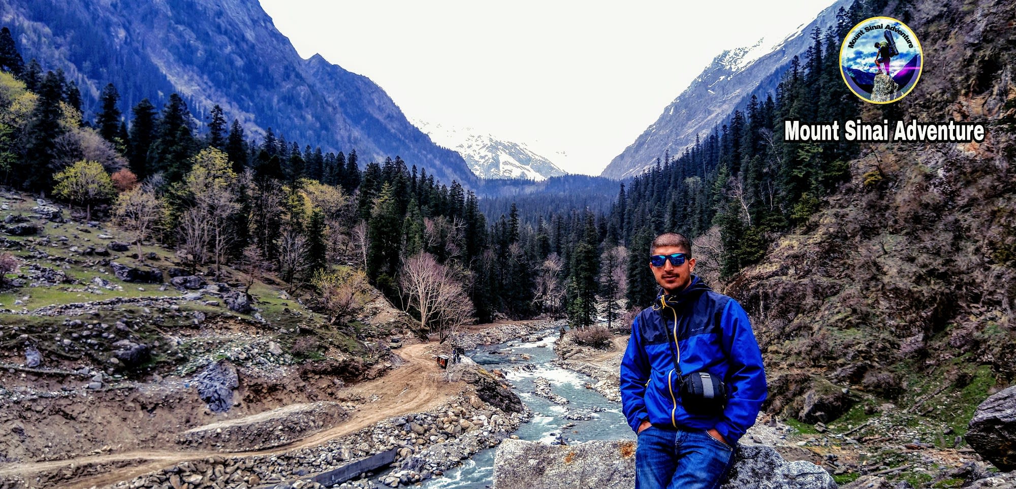 Pravesh standing in front of an river flowing through a valley