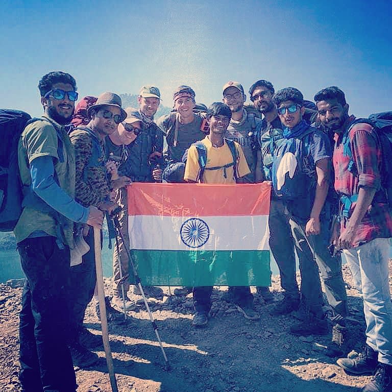 a group of people holding the indian flag on a trek with Mount Sinai Adventure