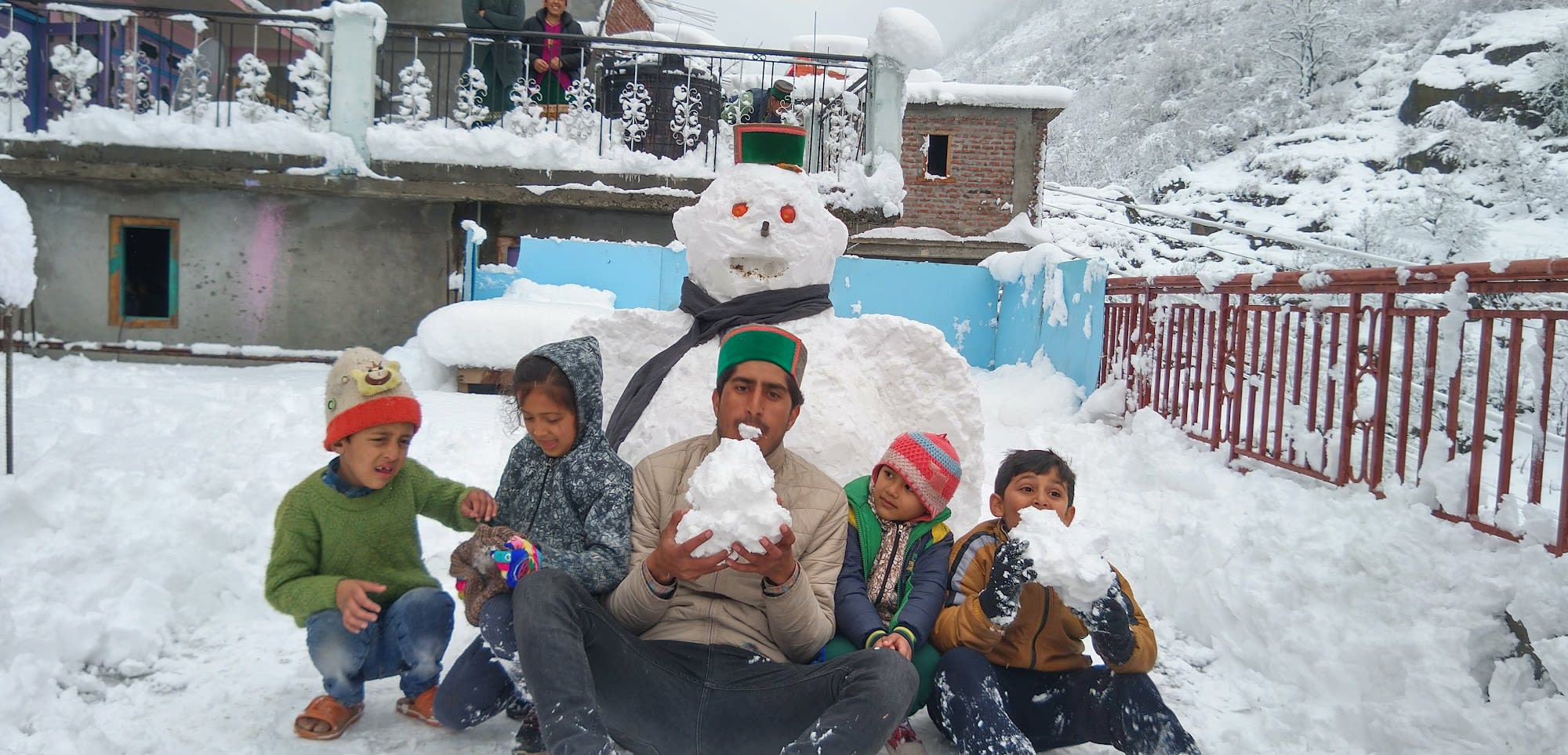 a group of peopel infront of a huge snow man