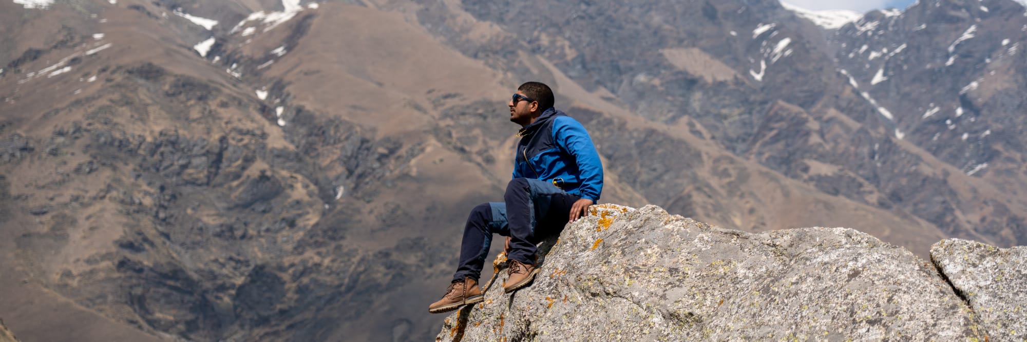 a person on a huge rock at Kara lake in Bhaba valley