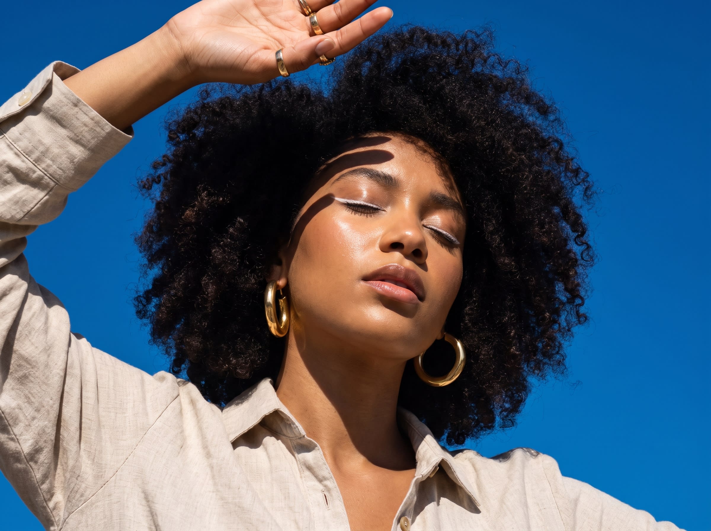 Woman with curly hair shielding face
