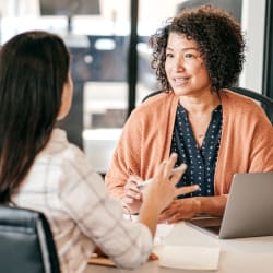 2 ladies talking over a laptop