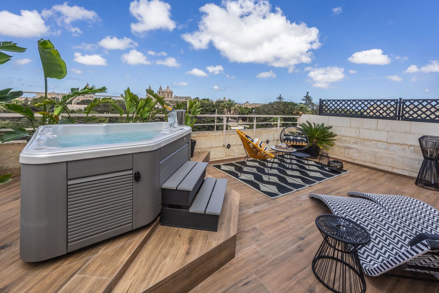 The rooftop terrace at Maison Medina, with a hot tub and views towards Mdina