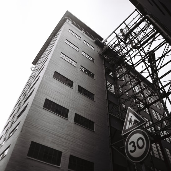 Photograph of a building looking from the ground up, with a 30 km/h sign visible.