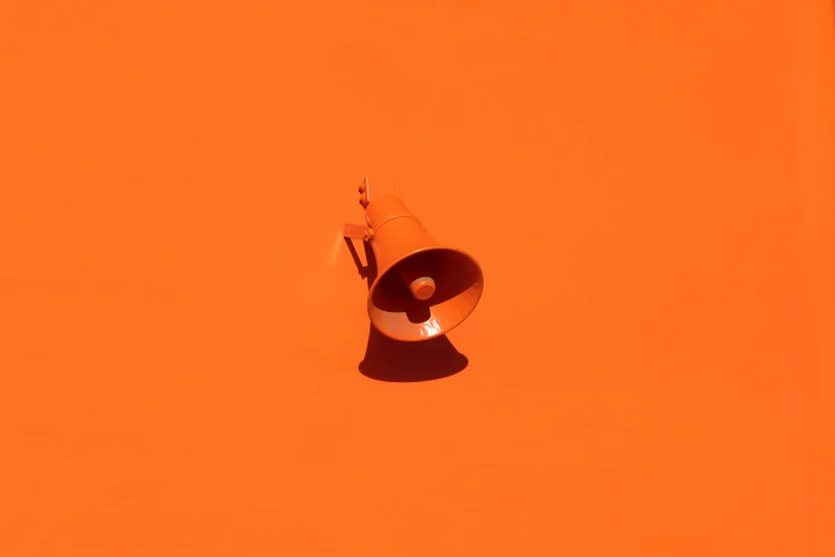 Um megafone sobre um forte fundo laranja