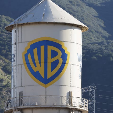 Warner Bros. logo is seen on the left, and the American flag is on the right.