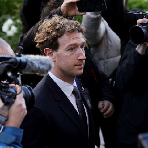 Mark Zuckerberg walks towards the courthouse while surrounded with security and media members.