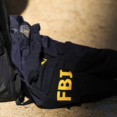 An FBI jacket seen on the ground half of it is in the shade.