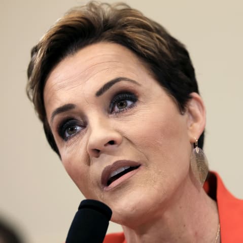 Kari Lake speaks into the mic in this diagonal closeup photo.