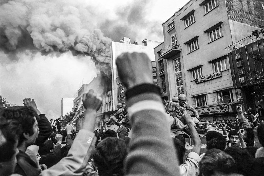 Troops loyal to Shah Mohammad Reza Pahlavi arrive to control a crowd of demonstrators outside a burning government building at the height of Islamic revolutionary fervor on Nov. 4 1978 in Tehran.