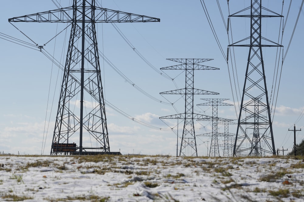 Transmission lines with snow on the ground are shown along the North Sam Houston Parkway near SH249.