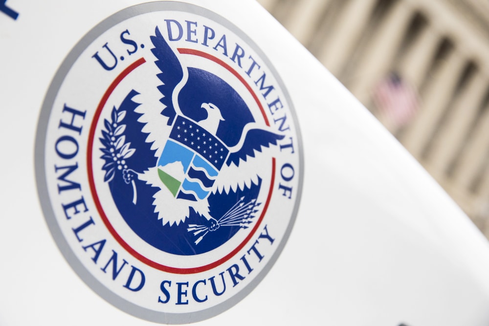 A closeup of DHS logo is seen on a vehicle in a diagonal angle.
