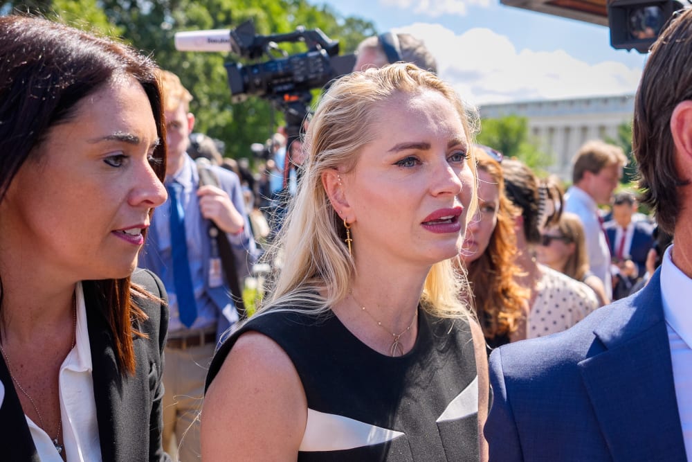 Anouska De Georgiou walks amongst her lawyers as she is crying.