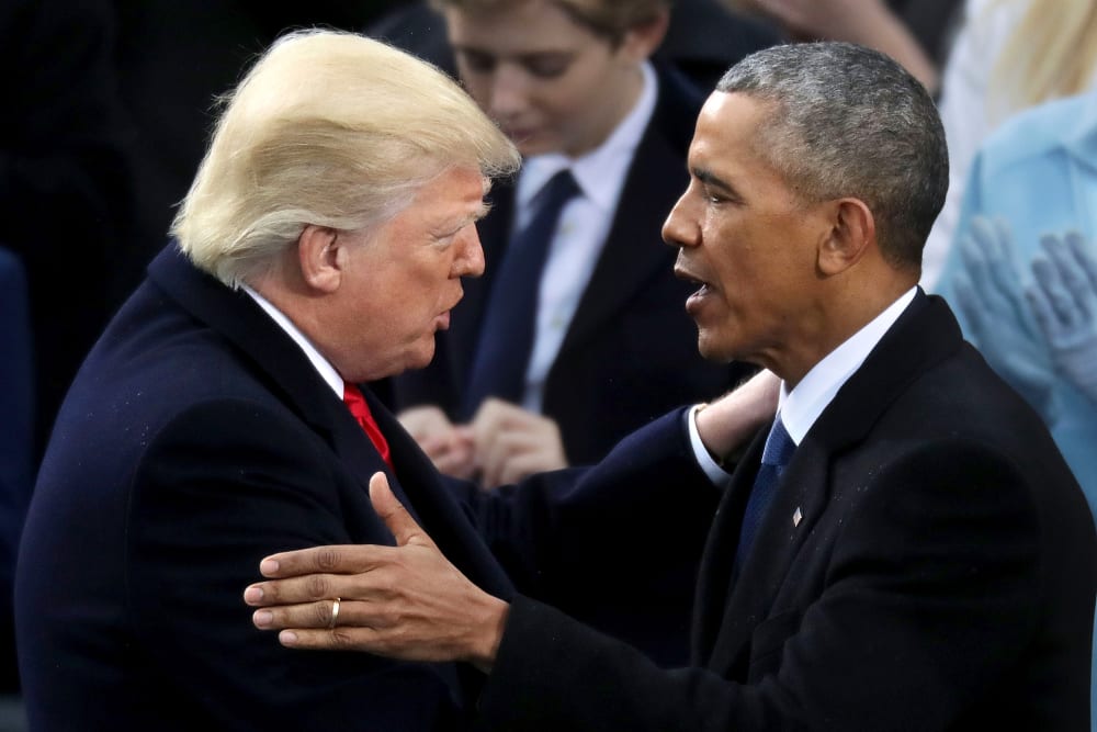 Donald Trump, left, and Barack Obama shake hands and touch each other on the shoulder.