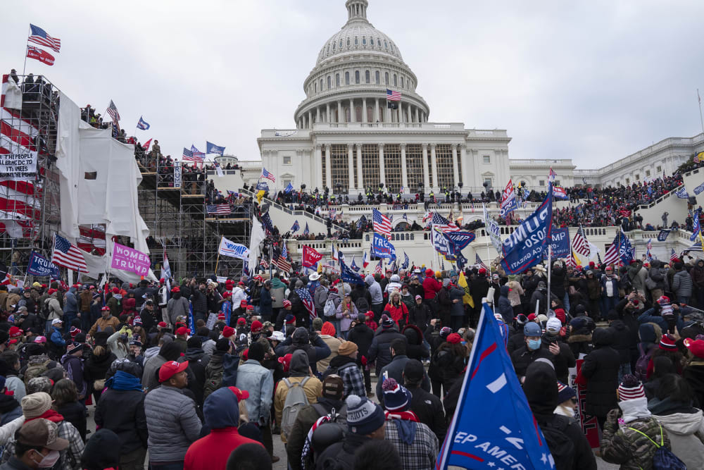 Protestors rush toward the Capitol building.