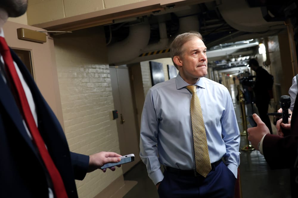 Jim Jordan has his hands in his pockets while speaking to the reporters.