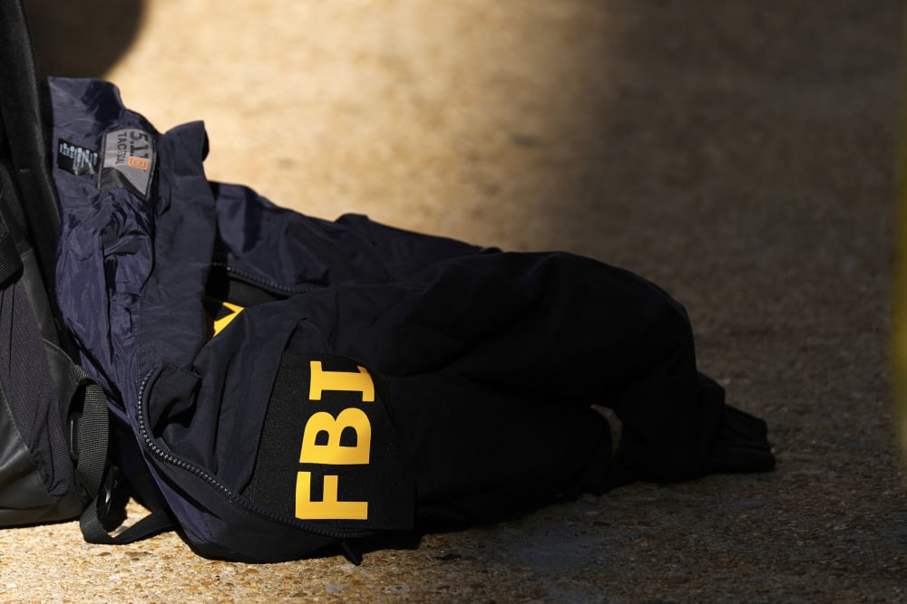 An FBI jacket seen on the ground half of it is in the shade.