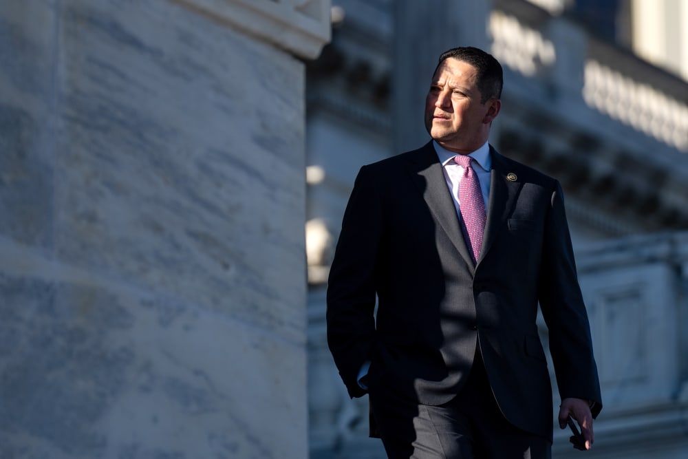 Tony Gonzales looks away as he walks down the steps where a small part of his face is in shade.