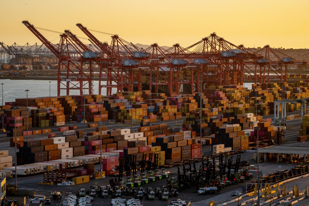 Shipping containers seen in a wide shot at sunset.