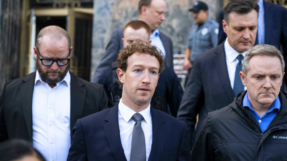 Mark Zuckerberg surrounded by others.