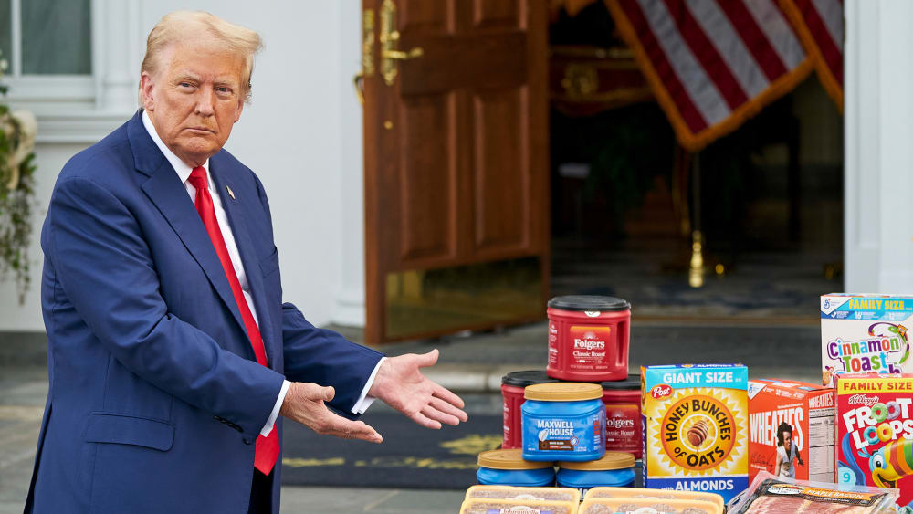 President Donald Trump gestures toward a table of groceries during a news conference.